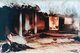 Vietnam: Unidentified bodies near burning house, My Lai, March 16, 1968